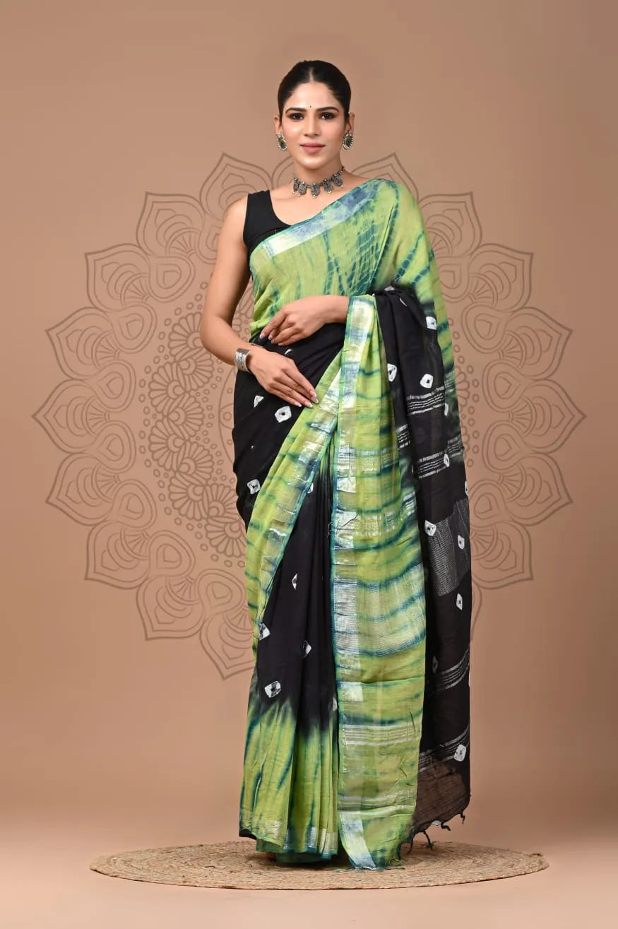 Woman wearing a black and green saree with a decorative background